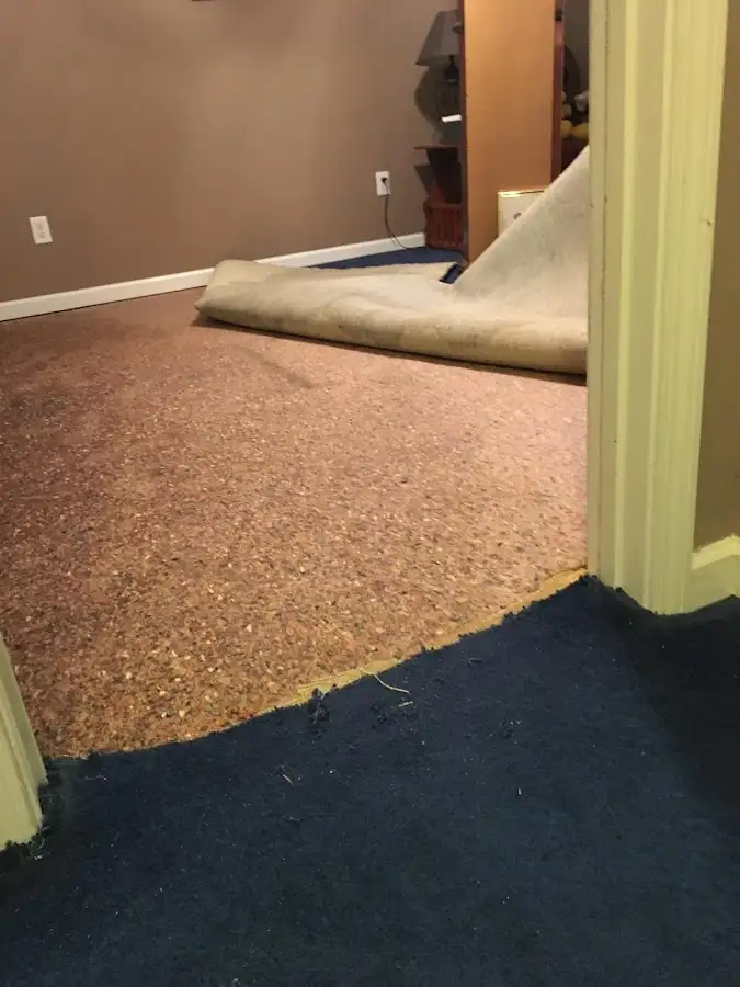 Carpet pad removal revealing water damage during Water Mitigation Services in Broussard